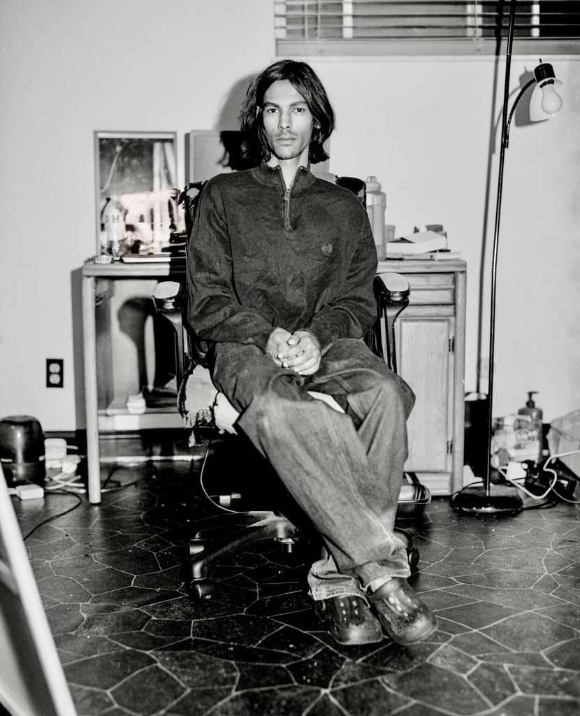 Full figure seated in a studio chair
