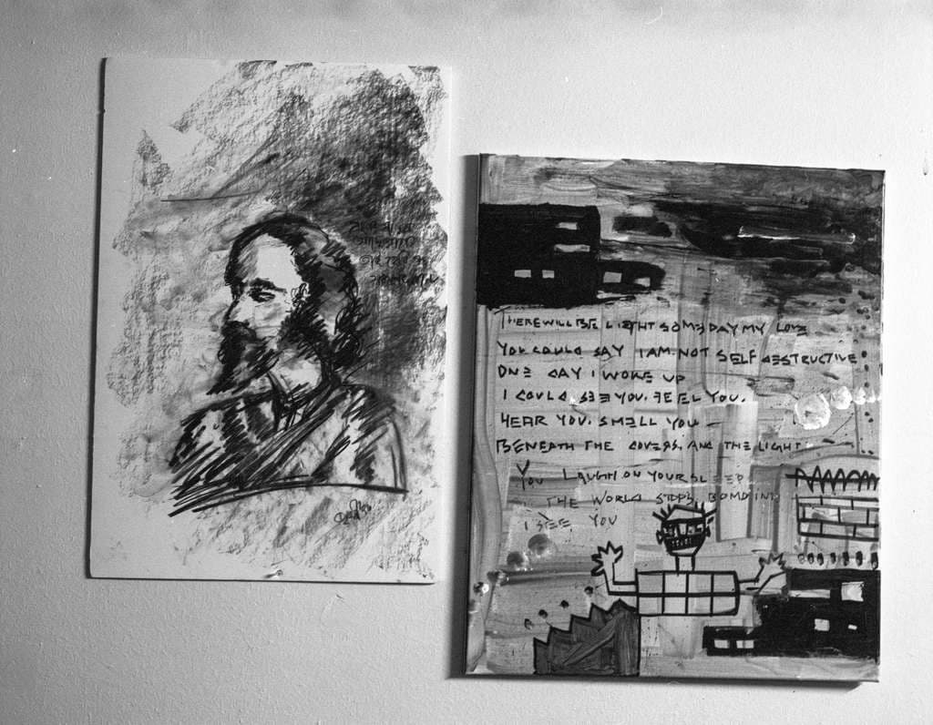 A charcoal drawing and a painted piece on the studio wall